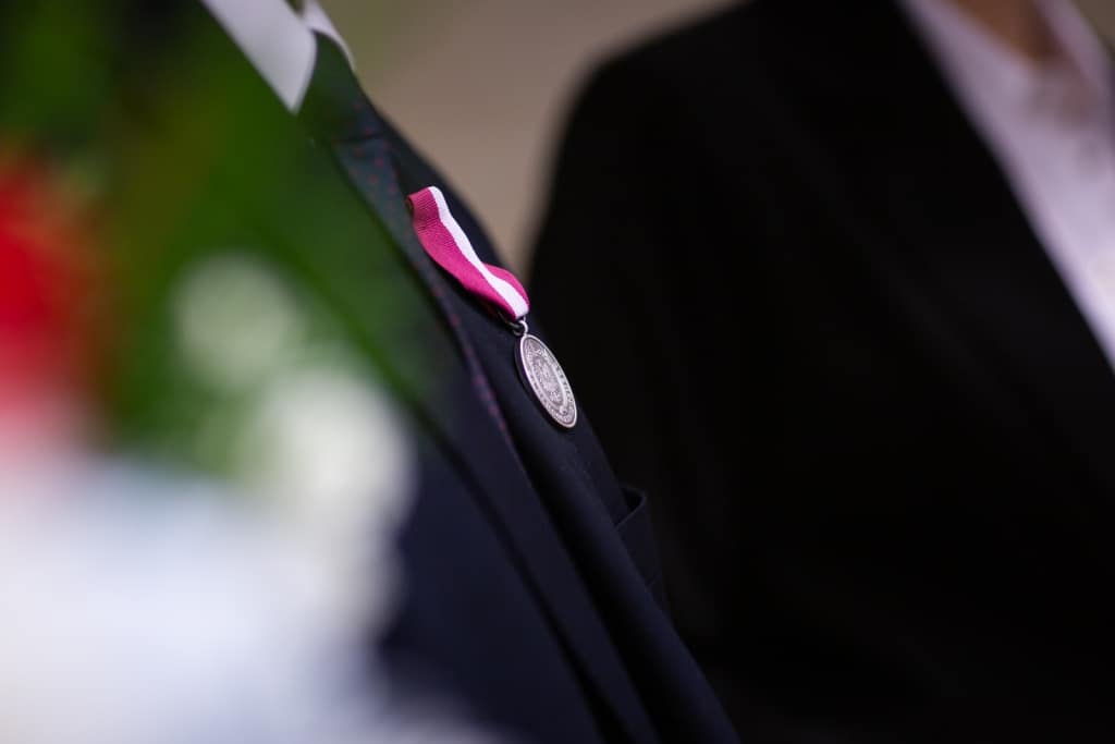 Medal z biało-czerwoną wstążką na garniturze podczas Inauguracji 2021/2022.