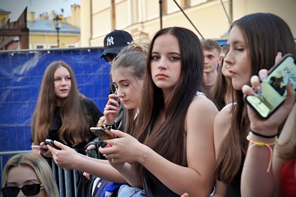 Młode kobiety z telefonami podczas Juwenaliów 2025