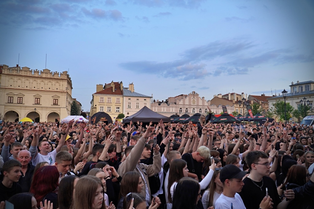 Tłum studentów na Juwenaliach 2025, ręce w górze, budynki w tle