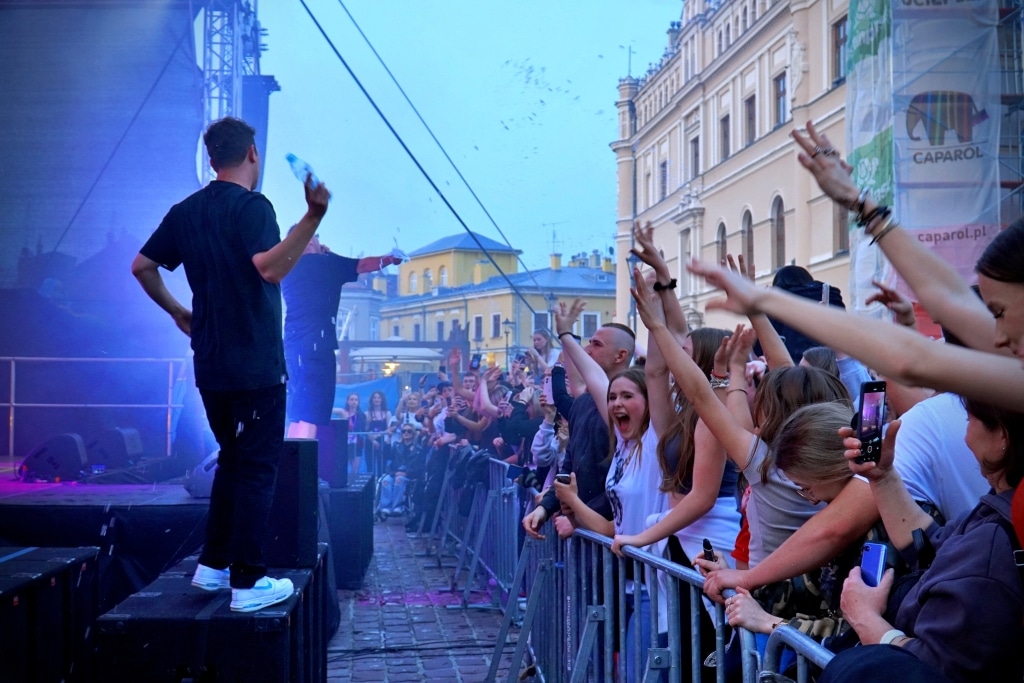 Artyści na scenie podczas Juwenaliów 2025, tłum fanów z rękami w górze