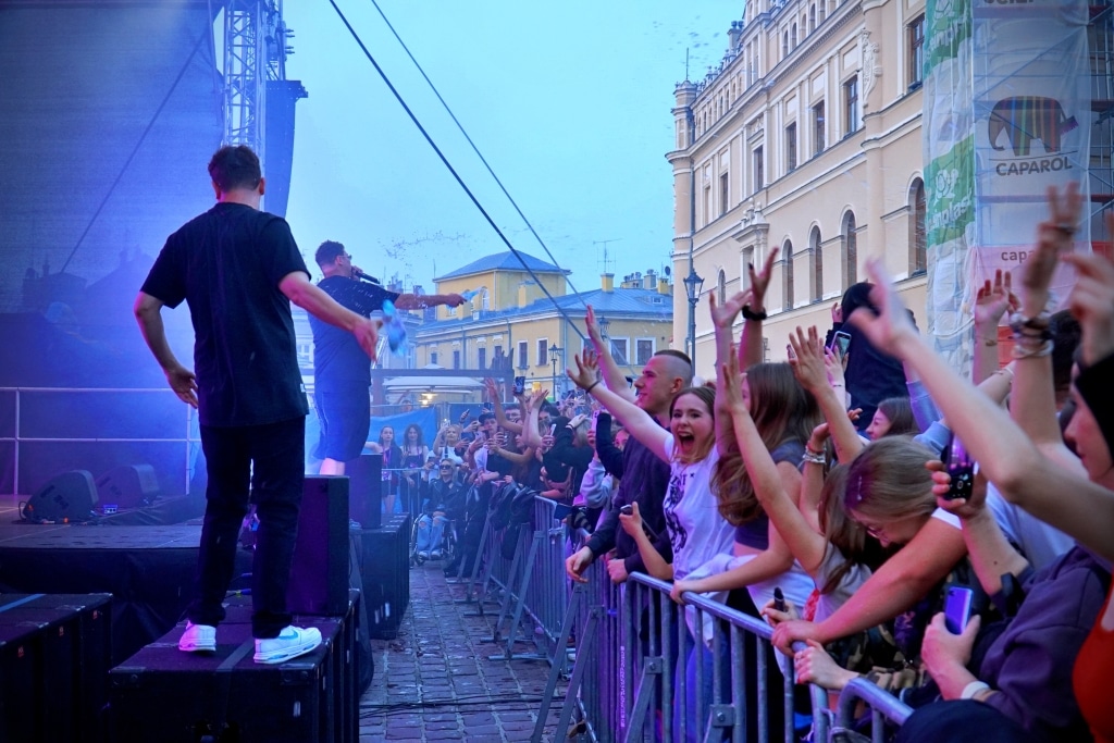 Artysta na scenie Juwenaliów 2025, tłum fanów z rękami w górze.