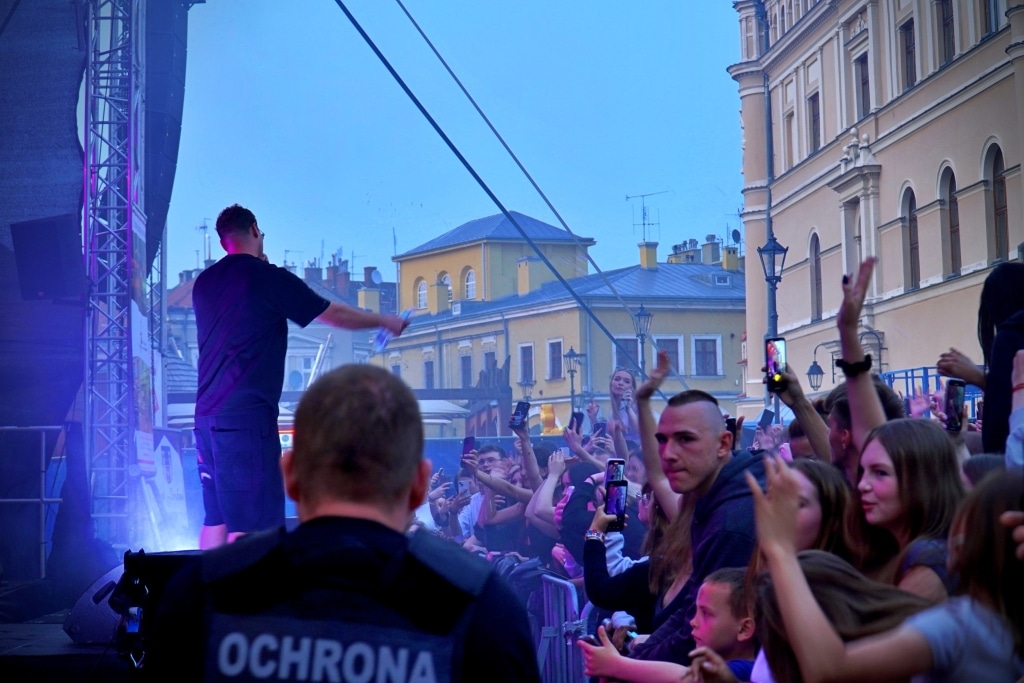 Koncert Juwenalia 2025: artysta na scenie, tłum z telefonami w rękach.