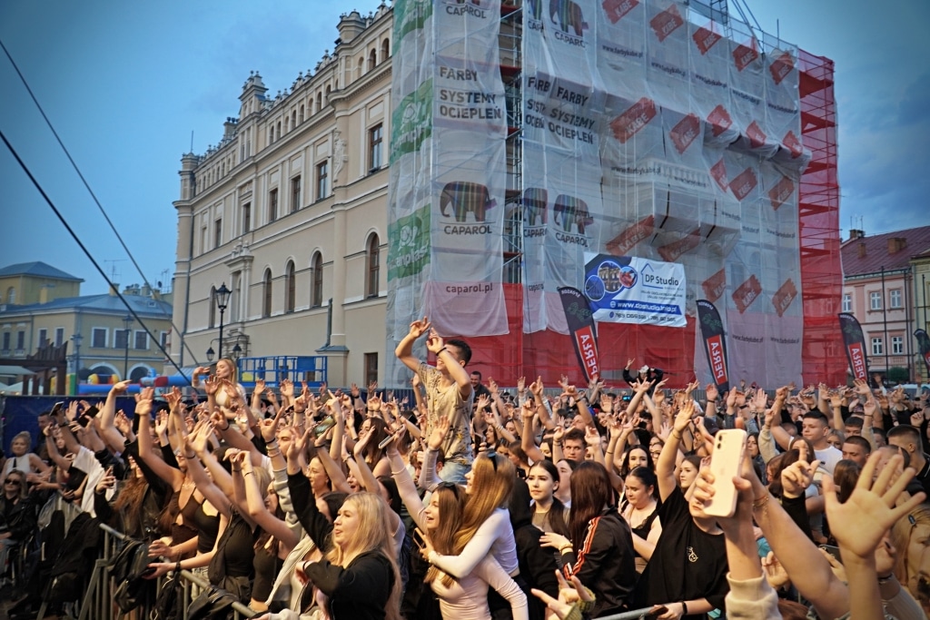 Tłum ludzi na Juwenaliach 2025, scena z artystą i budynek w budowie.