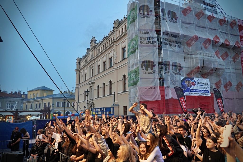Tłum ludzi na koncercie Juwenalia 2025 przed budynkiem z banerami