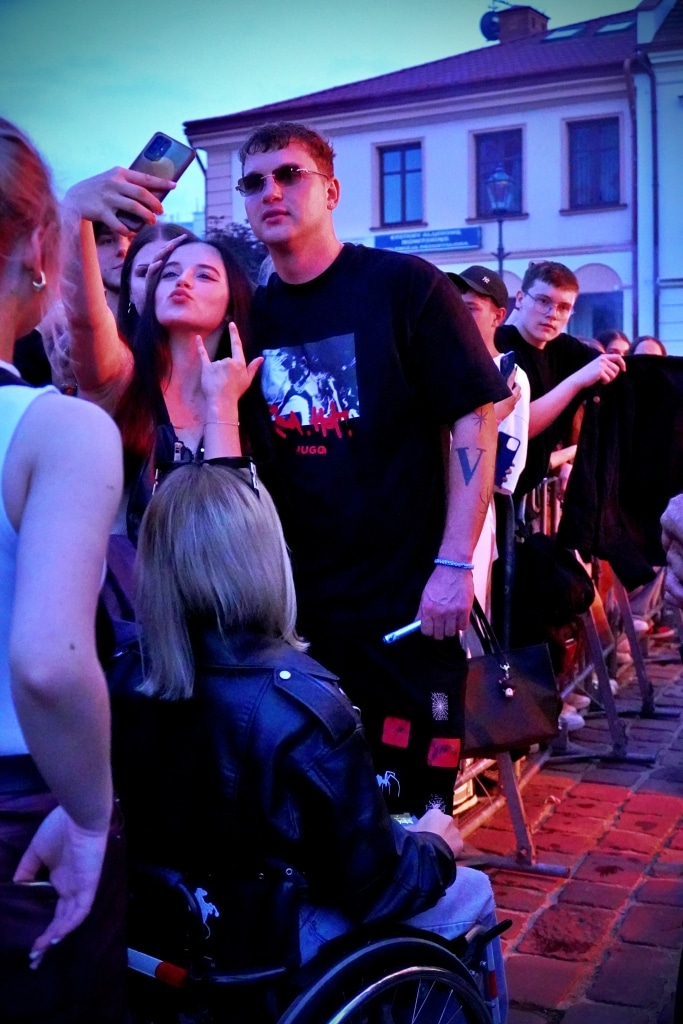 Młodzi ludzie na Juwenaliach 2025, w tym osoba na wózku inwalidzkim.