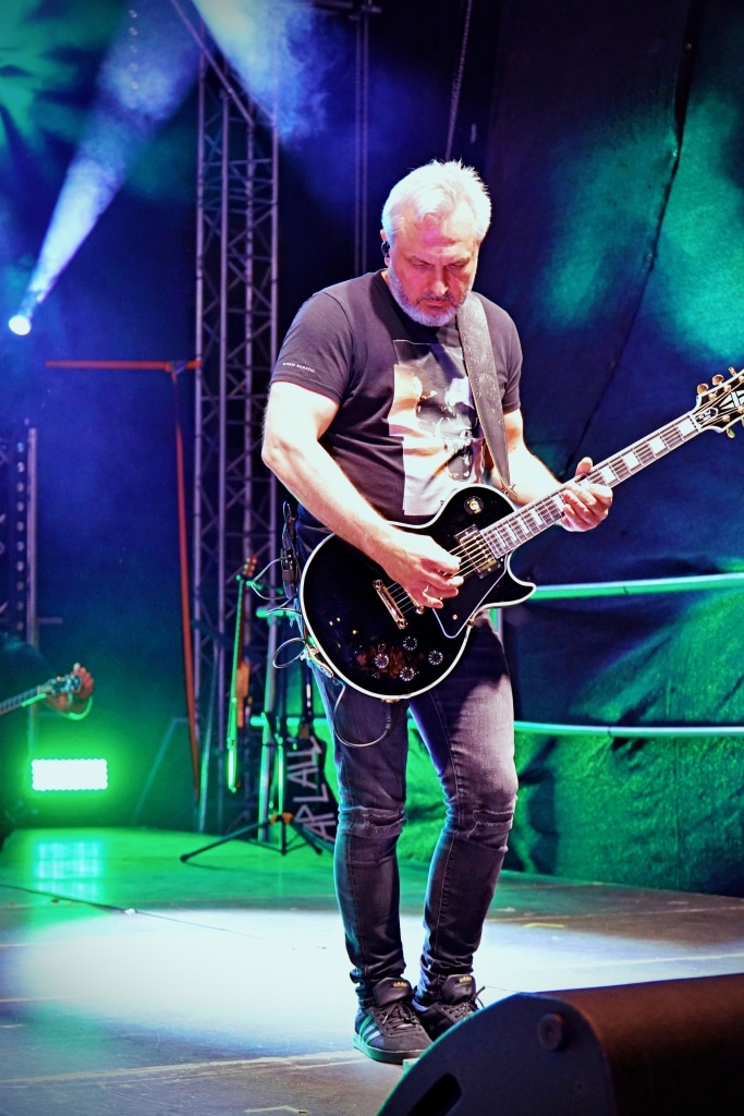Mężczyzna gra na gitarze elektrycznej na scenie podczas koncertu Juwenalia 2025.