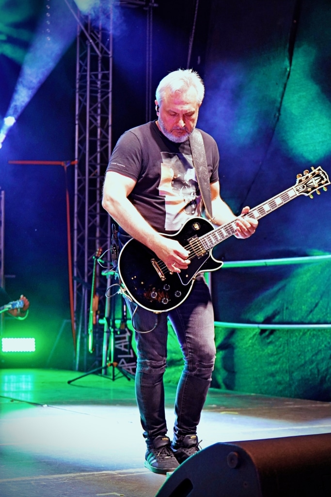 Mężczyzna gra na gitarze elektrycznej na scenie podczas Juwenaliów 2025.
