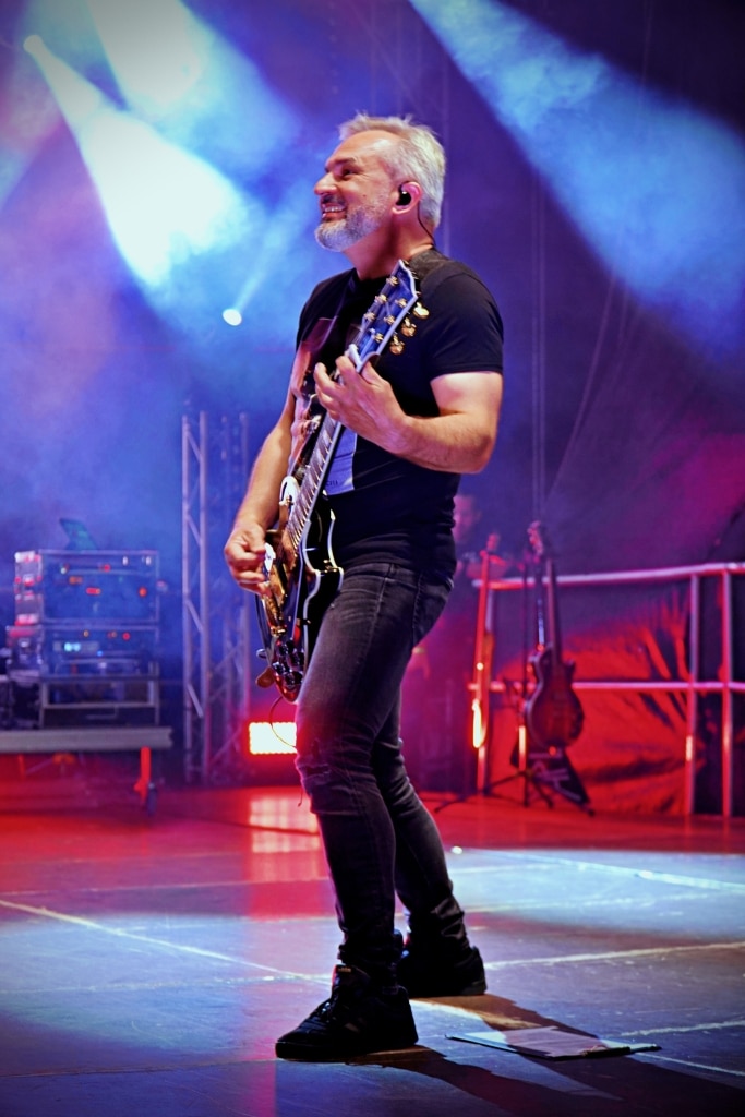 Gitarzysta z siwą brodą gra na scenie na Juwenaliach 2025