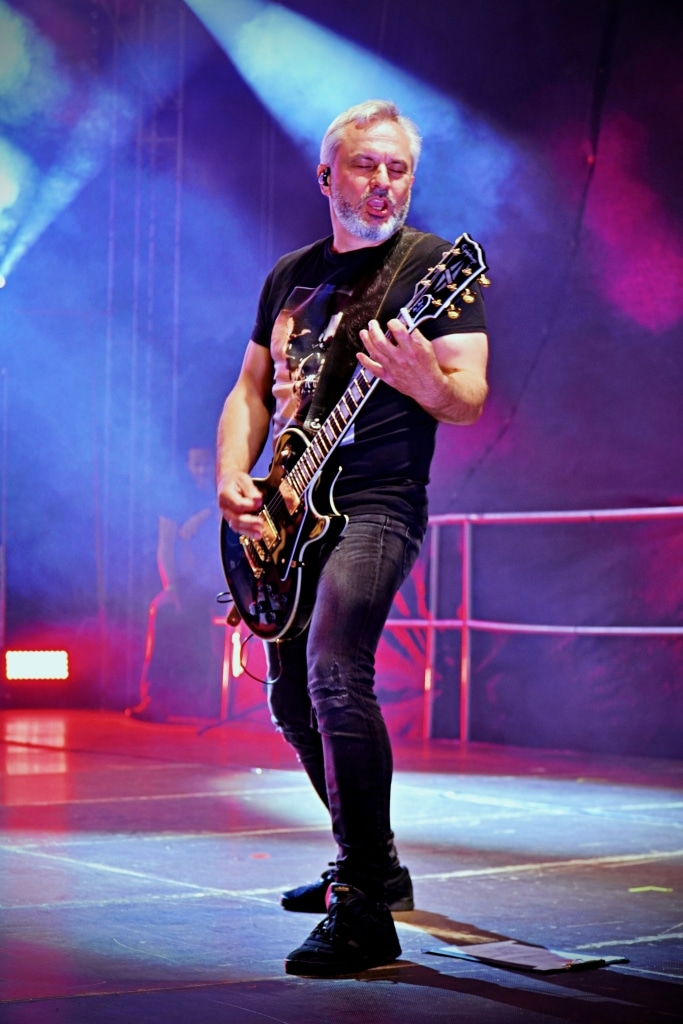 Gitarzysta na scenie Juwenaliów 2025, grający na czarnej gitarze elektrycznej.