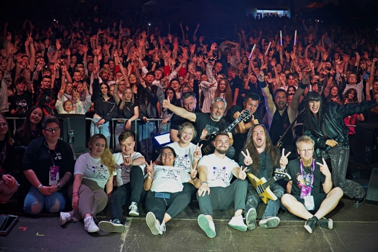 Grupa fanów na Juwenaliach 2025 z zespołem na scenie