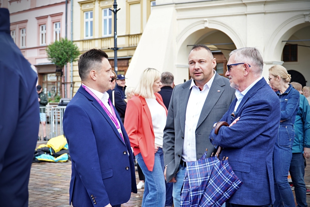 Mężczyźni w garniturach rozmawiają na Juwenaliach 2025 z parasolem