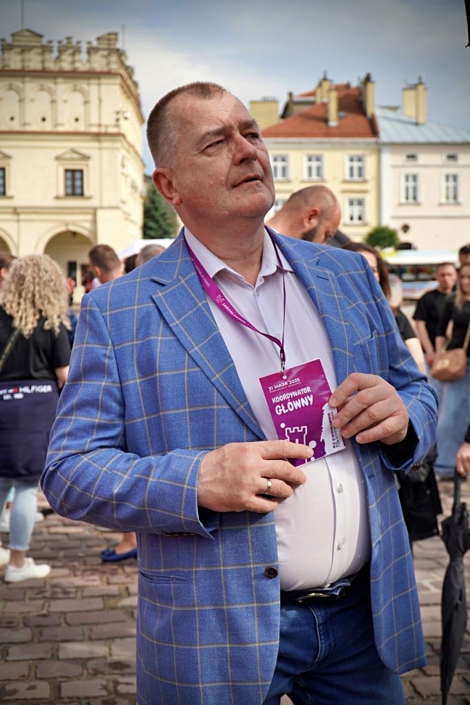 Mężczyzna w marynarce z identyfikatorem koordynatora na Juwenaliach 2025