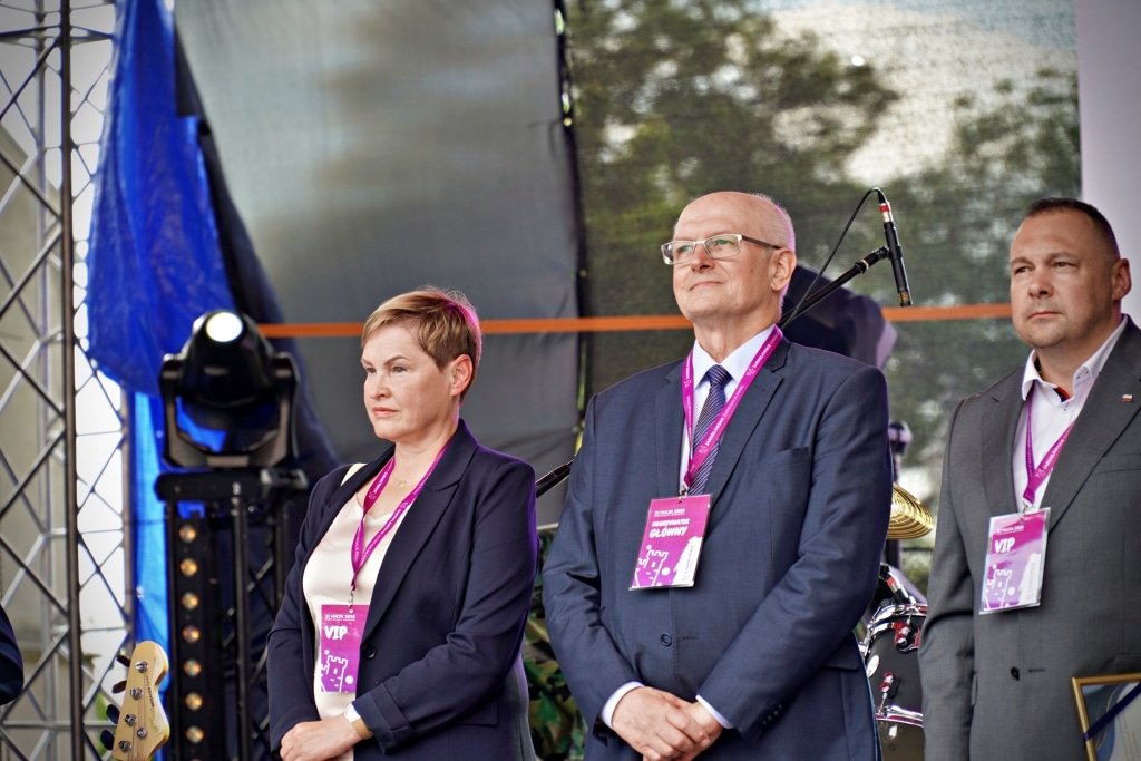 Kobieta i mężczyźni w garniturach z identyfikatorami VIP na Juwenaliach 2025.