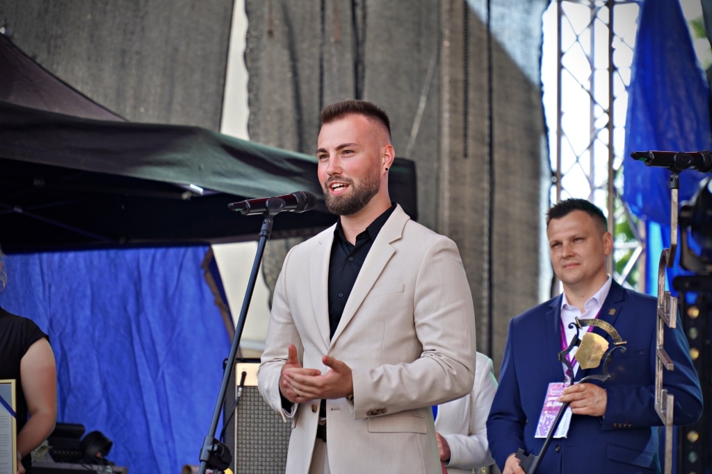 Mężczyzna w garniturze przemawia na scenie podczas Juwenaliów 2025