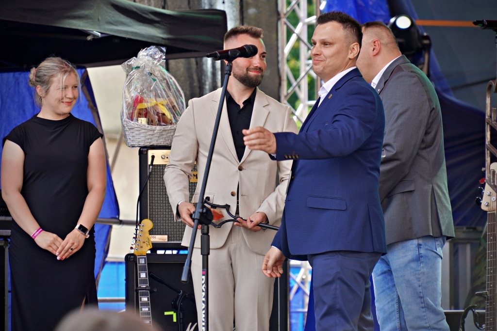 Uroczystość na Juwenaliach 2025: mężczyźni w garniturach i kobieta w czarnej sukience.