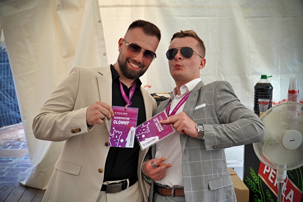 Dwóch mężczyzn w garniturach na Juwenaliach 2025 z identyfikatorami.