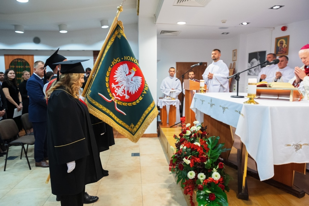 Kobiety w czerni w sali z kwiatami i flagą