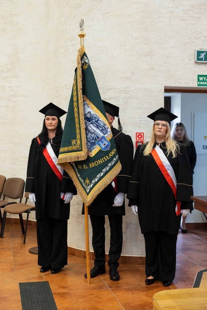 Inauguracja 2025/2026: studenci z flagą w togach akademickich