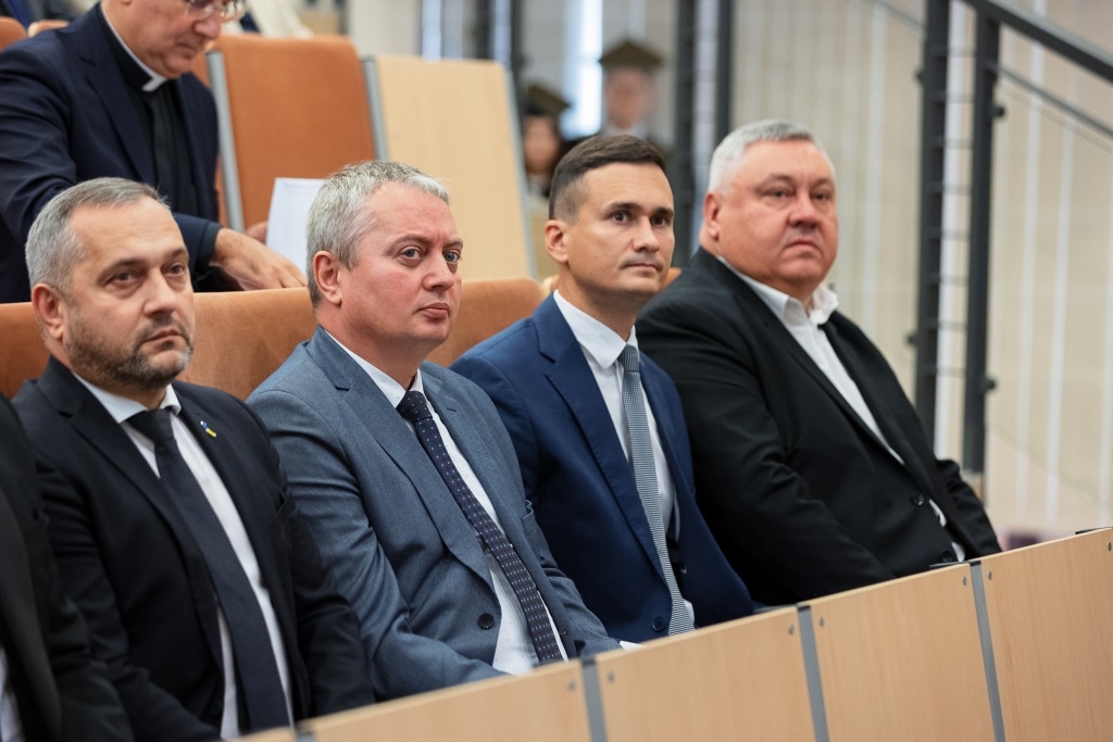 Uczestnicy inauguracji roku akademickiego 2025/2026 siedzą w pierwszych rzędach sali wykładowej.