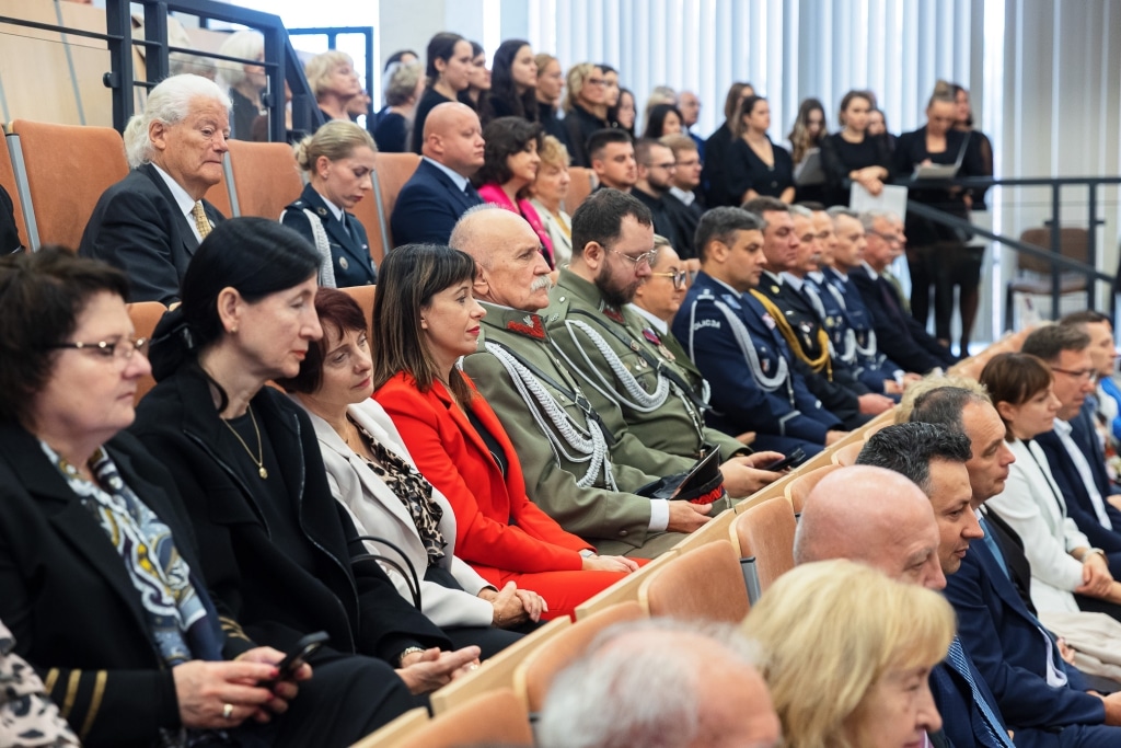 Uczestnicy inauguracji roku akademickiego 2025/2026 siedzą na sali.