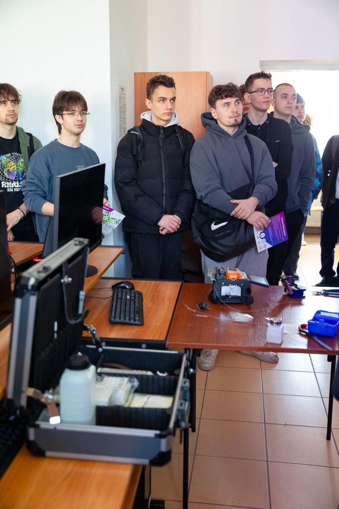 Uczestnicy Dnia Otwartego 2025 stojący w sali z wyposażeniem laboratoryjnym.