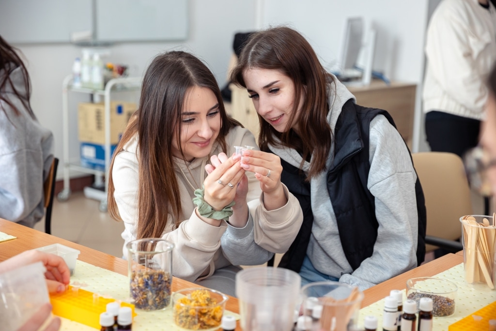 Dwie studentki na Dniu Otwartym 2025 badają składniki do produkcji kosmetyków.