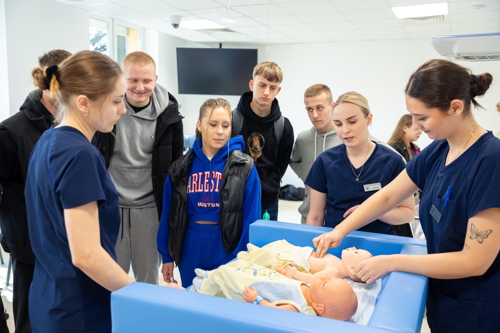Studenci medycyny na Dniu Otwartym 2025 ćwiczą na fantomie niemowlęcia.