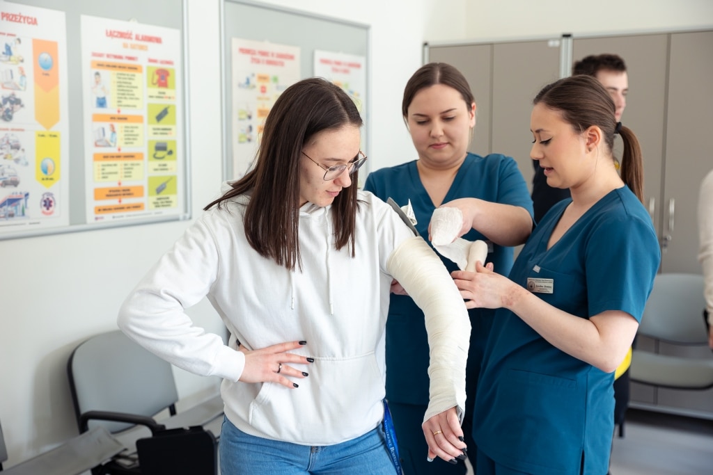 Uczestnicy dnia otwartego 2025 uczą się bandażować rękę