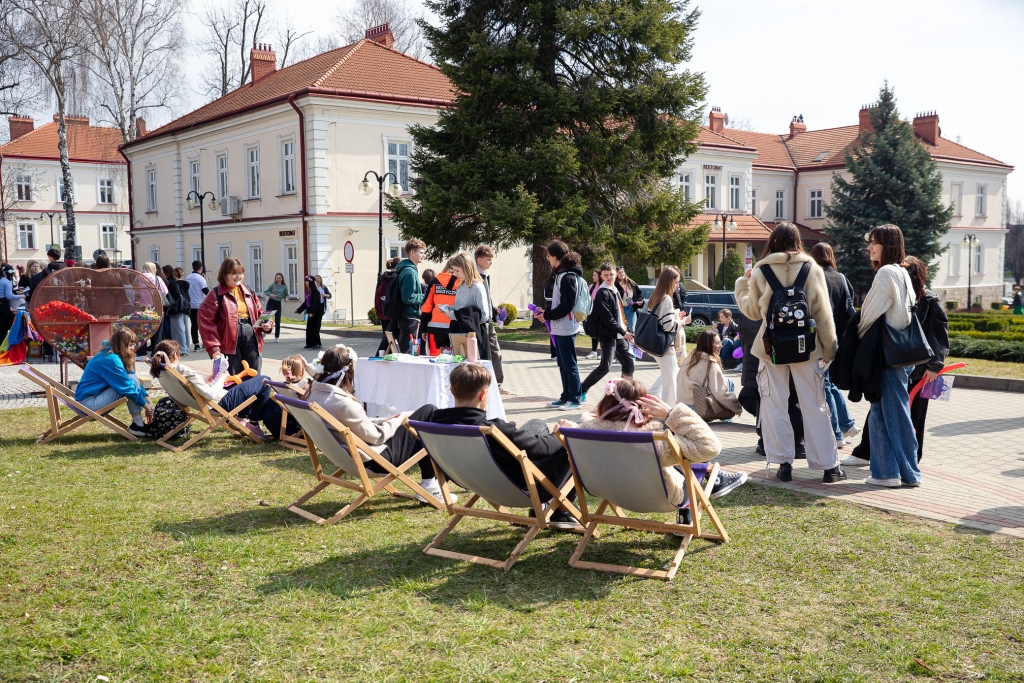 Dzień Otwarty 2025: Młodzież wypoczywa na trawie przed budynkiem