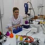 Studentka w laboratorium bada płyny w probówkach, baza dydaktyczna