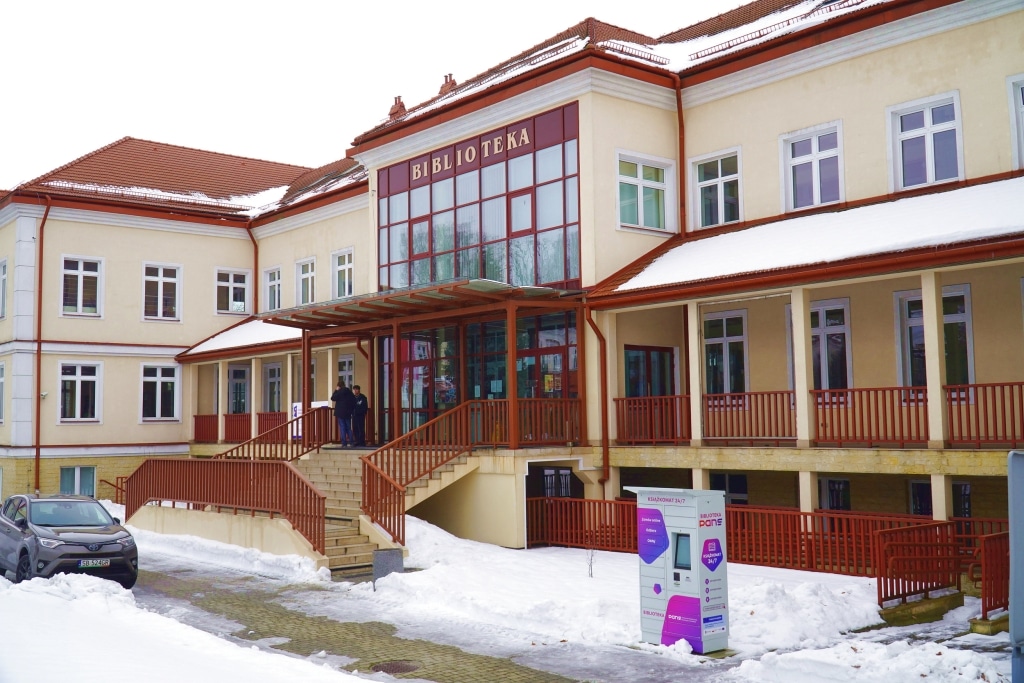 Biblioteka PANS w zimowej scenerii, z automatem do odbioru książek.