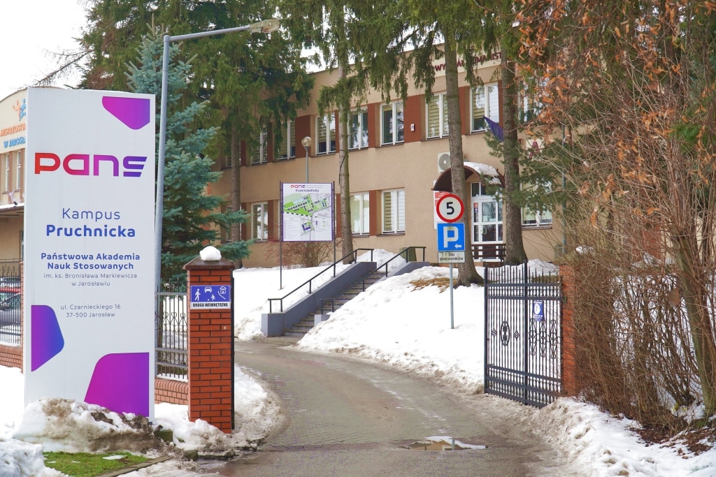Kampus PANS w Jarosławiu: budynek uczelni z tablicą informacyjną.