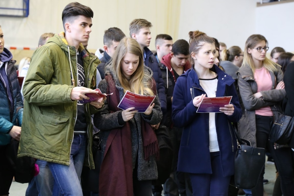 Młodzi ludzie na Dniu Otwartym 2017, czytający materiały