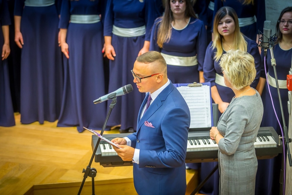 Inauguracja 2018/2019: Mężczyzna przemawia przy keyboardzie przed chórem