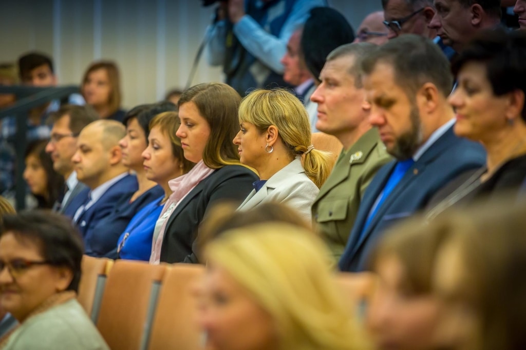Uczestnicy inauguracji roku akademickiego 2018/2019 siedzą w sali.