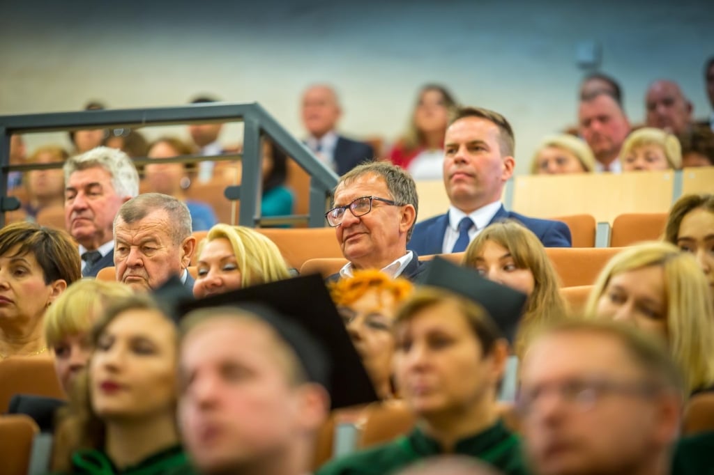 Uczestnicy inauguracji roku akademickiego 2018/2019 siedzą na sali.