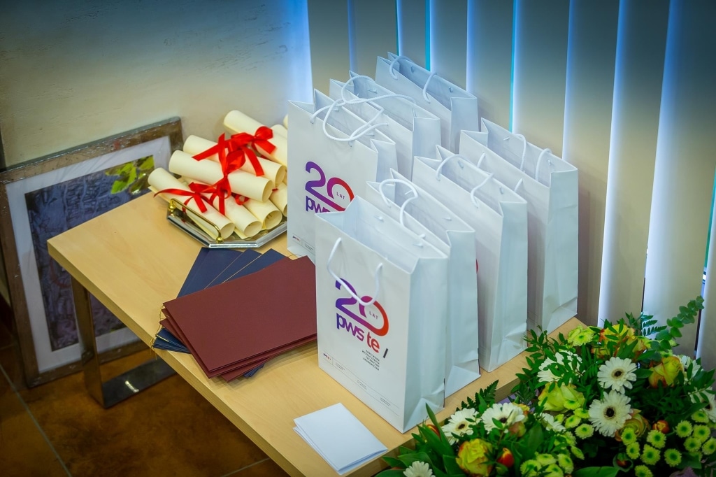 Inauguracja 2018/2019: białe torby, dyplomy i kwiaty na stole